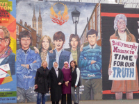 DPI Participants Melda Onur, Özlem Zengin, Zehra Taşkesenlioğlu and Nurcan Baysal stand in front of murals on the Falls Road.